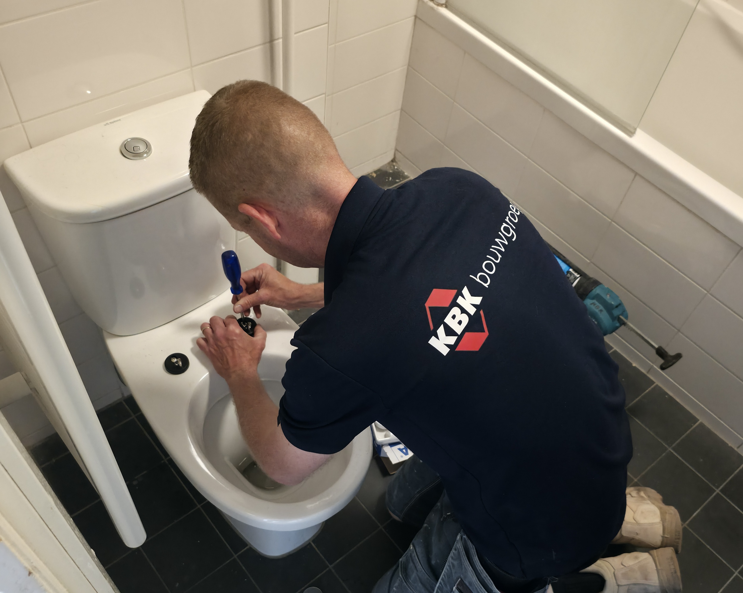 timmerman werkt wc af om woning op te leveren.